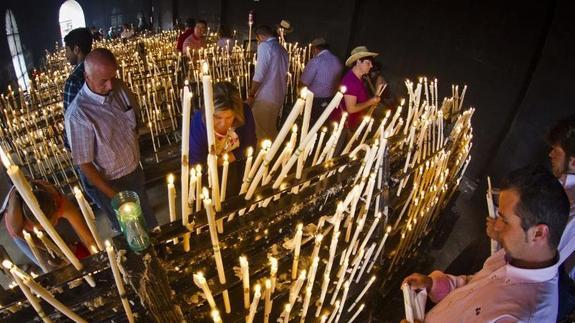 Devotos de la Virgen del Rocío encienden velas en la ermita.