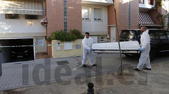 Momento en el que era retirado el cadáver de la vivienda de Armilla. 