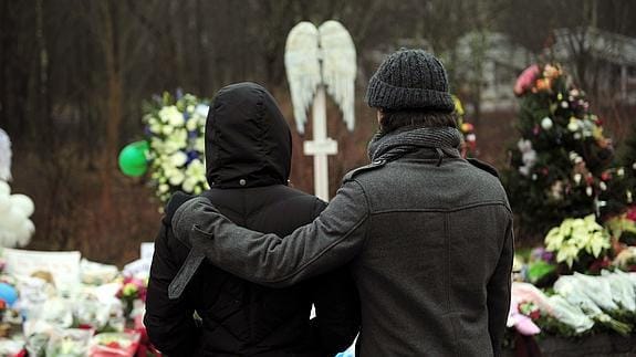 Dos personas frente a un santuario improvisado en memoria de las víctimas del tiroteo de Sandy Hook, en Newtown.