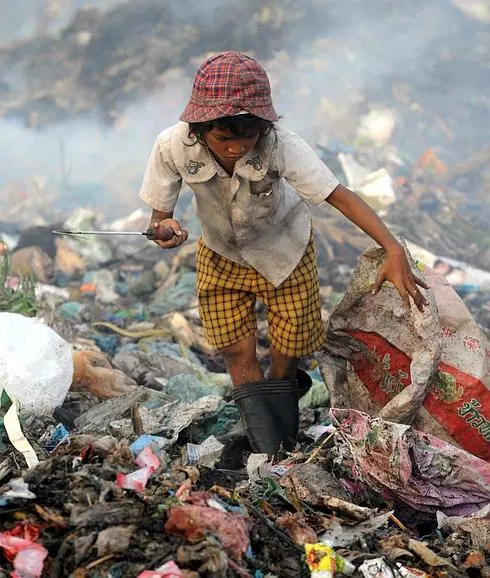 Una niña camboyana trabaja buscando material reciclable. 