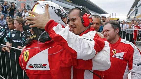 Vettel recibe la felicitación de un miembro de Ferrari. 