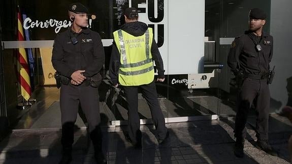 Agentes ante la sede de CDC en Barcelona que está siendo registrada.