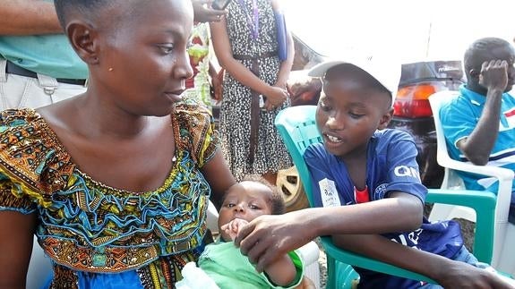 Abraham Gbotoe, a la derecha, un superviviente de ébola se reencuentra con su familia.