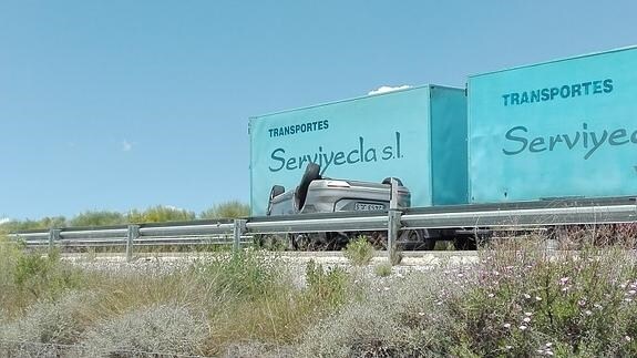 Uno de los vehículos implicados en el accidente, volcado en la autovía. 