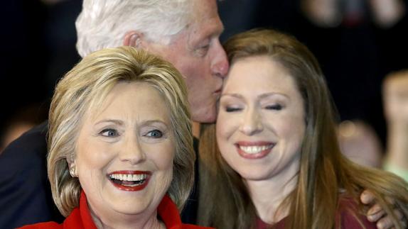 Hillary Clinton, delante de su marido Bill y su hija Chelsea.