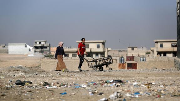 Dos personas caminan en un descampado del noreste de Mosul.