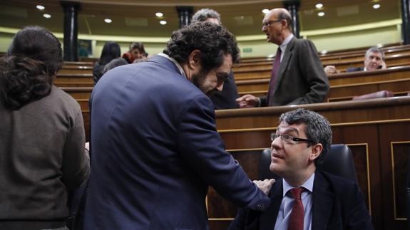 Álvaro Nadal, ministro de Energía (d), dialoga con el diputado de Ciudadanos Miguel Gutiérrez en el Congreso.