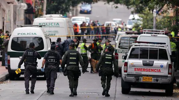 Miembros de la Policía de Colombia examinan el lugar donde se registró una explosión.