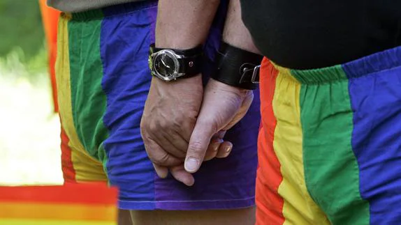 Una pareja se da la mano mientras participa en una marcha con motivo del día internacional del orgullo gay. 