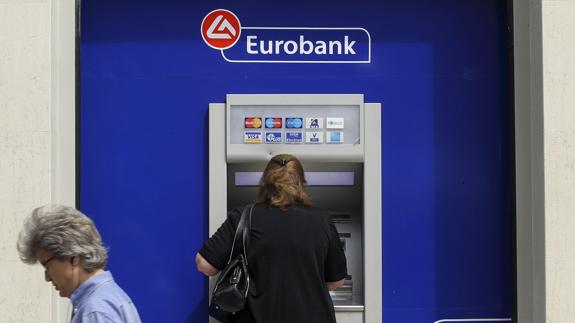Una mujer utiliza un cajero de Eurobank en Atenas, Grecia.