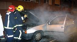 Bomberos sofocan un coche que ardió por un pertardo en Bilbao en la Nochevieja de 2004. / L. Calabor