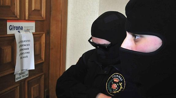 Dos policías de la 'operación Pokemon' en la sede municipal de Turismo de Girona.