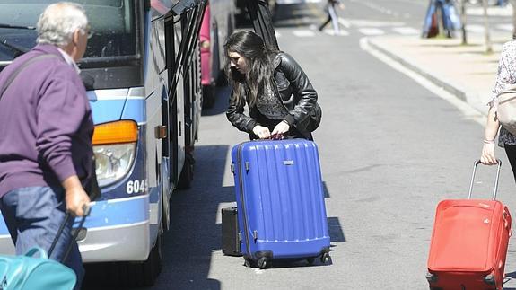 Viajeros cargan sus maletas en un autobús de largo recorrido.