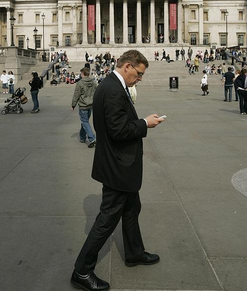 Un hombre consulta su móvil desde Trafalgar Square, en Londres.
