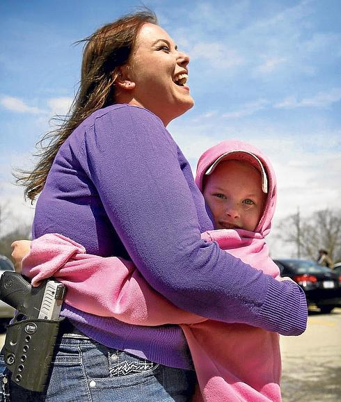 Nichole Powell acude junto a su hija a una concentración en favor de la libertad de portar armas en Michigan, con su pistola ‘Taurus 709 Slim’ a la vista.