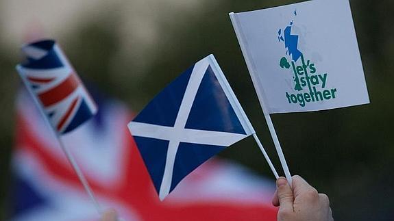 Una bandera escocesa y una británica junto a una enseña con el lema 'Mejor juntos'.