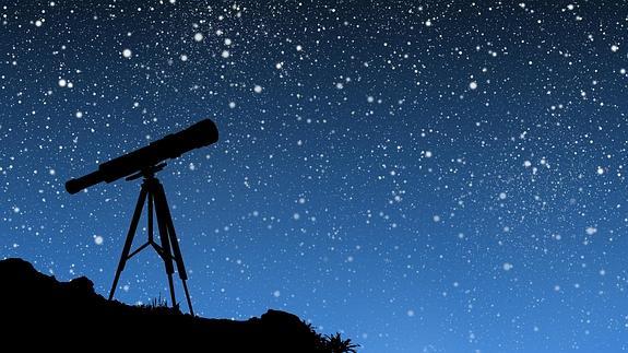 Telescopio orientado hacia un firmamento tachonado de estrellas.