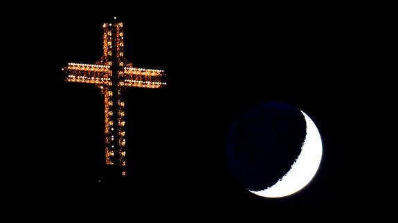 La luna se refleja sobre la cruz del milenio, en la montaña Vodno de Macedonia. 