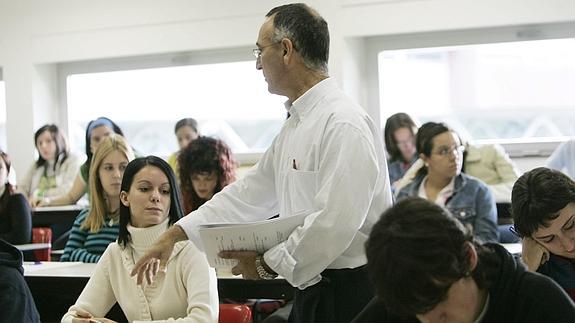 Un profesor reparte un examen a sus alumnos.
