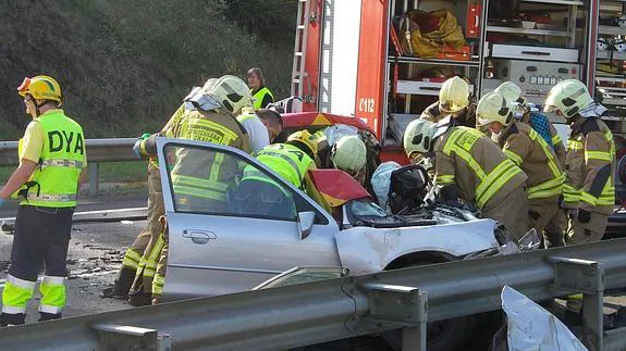 Los bomberos tratan de rescatar al conductor tras sufrir el violento accidente en Igorre.