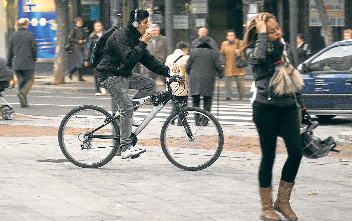 Un ciclista circula -con auriculares- por una acera de la capital riojana.