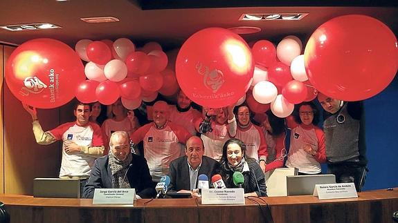 Naiara García de Andoin, con Cosme Naveda y Jorge García del Arco. Detrás, voluntarios con los globos que simbolizan la campaña navideña.