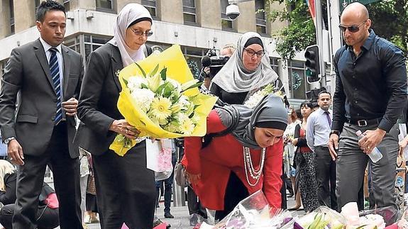 Musulmanes depositan flores por las víctimas del secuestro.