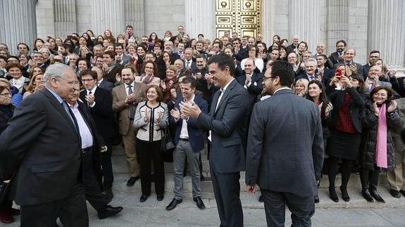 El diputado socialista Alfonso Guerra (i), es aplaudido por el líder socialista, Pedro Sánchez (c), y el resto de diputados este jueves a las puertas del Congreso.