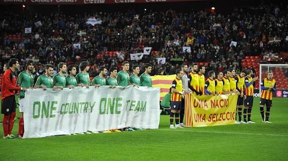 Los jugadores sujetan pancartas antes del encuentro.