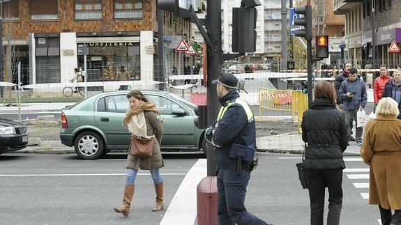 Un agente municipal advierte a una mujer que pasa el semáforo en rojo.