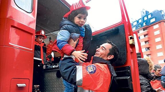 Un bombero baja del camión a un niño.