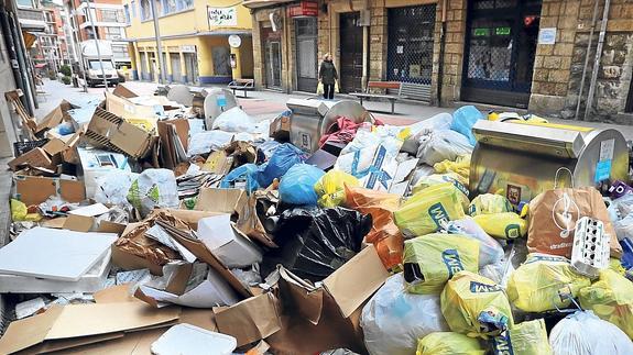 Cartones y basuras se amontonan en una calle de Algorta. 