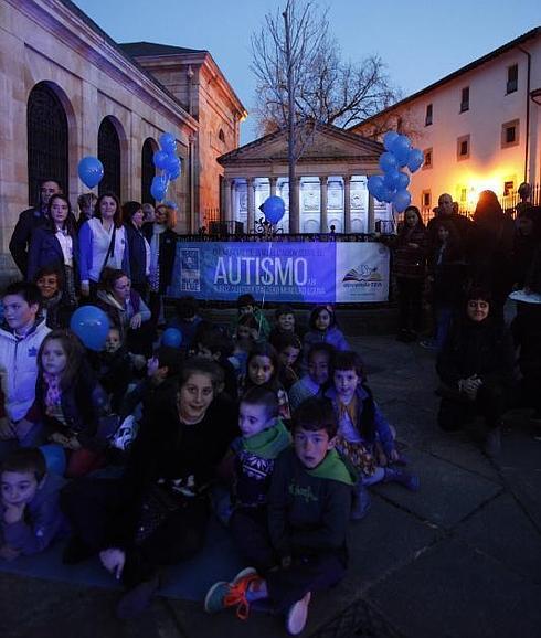 Pequeños de aprendeTEA posan delante del Árbol de Gernika teñido de azul.