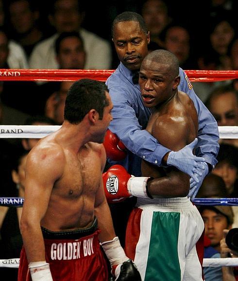 Un árbitro sujeta a Floyd Mayweather en su combate contra Oscar de la Hoya.