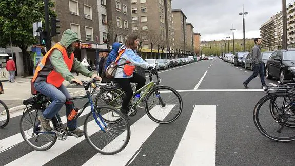Cicloturistas cruzan la Avenida de Gasteiz en bici por un paso de cebra. 
