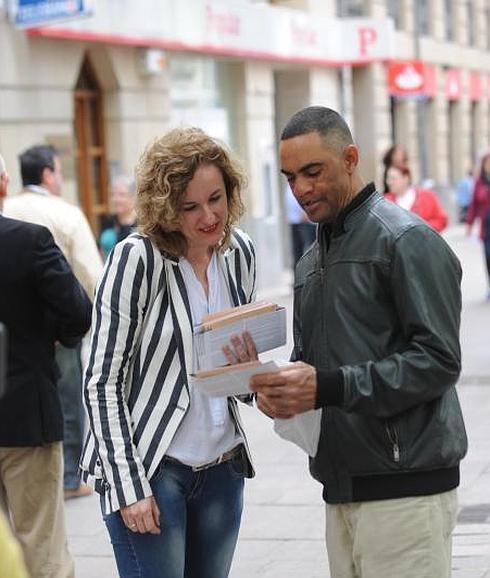 Cristina González muestra su folleto electoral a un ciudadano. 