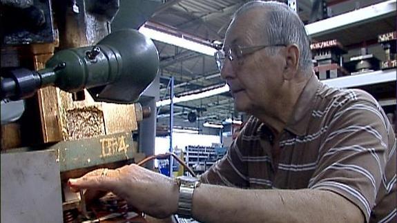 Una persona mayor trabajando en una fábrica.