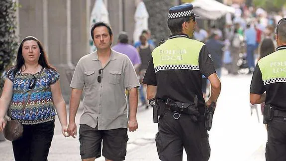 Dos agentes de la Policía Local realizan su ronda por la calle Portales; un centenar de agentes formará parte del dispositivo de seguridad de San Bernabé.