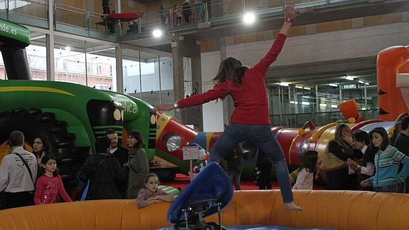 Unos niños se divierten saltando en hinchables.