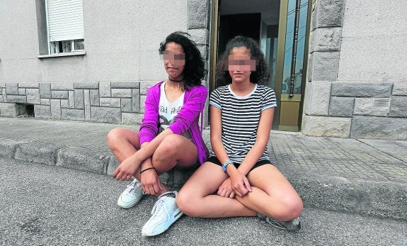 Olaya Bandín y Raquel García, con pantalón corto, posan frente a la casa de la segunda.