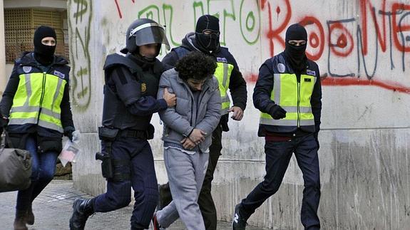 Agentes de la Policia Nacional trasladan a uno de los detenidos en una operación contra una célula yihadista en Melilla en marzo de 2014.