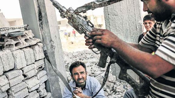 Un combatiente examina armas incautadas al Estado Islámico en el enclave sirio de Kobani, en el norte del país.