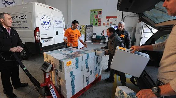 Voluntarios recogen una donación hecha al Banco de Alimentos para su posterior reparto