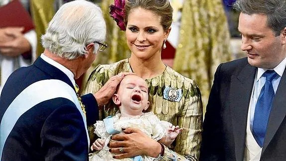 El rey Carlos Gustavo acaricia a su nieto.