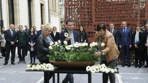 El presidente de Sortu, Hasier Arraiz, deposita una flor durante el acto celebrado en el Parlamento vasco.