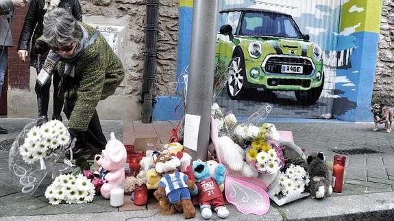 Una mujer deja una vela en la calle Libertad, en recuerdo a Alicia.