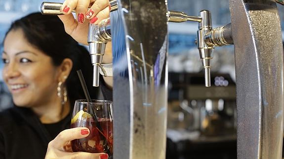 Una camarera sirve un vermú.