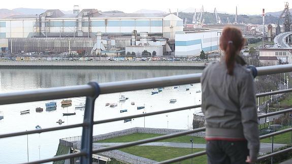 Una mujer observa la fábrica de la ACB de Sestao.