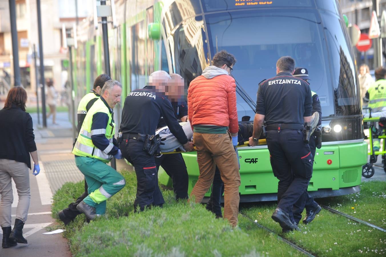Ciudadanos, ertzainas y sanitarios ayudan al joven tras el impacto.