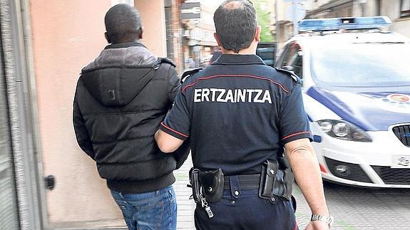 Un ertzaina acompaña a un arrestado en un operativo anterior. 